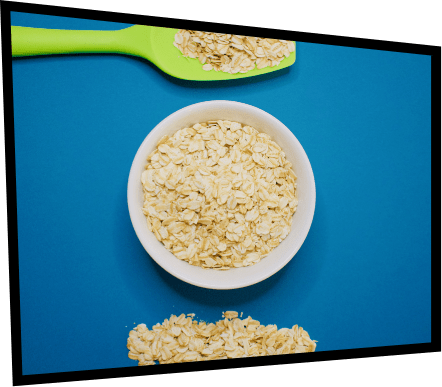 oats in a bowl with spoon on blue background